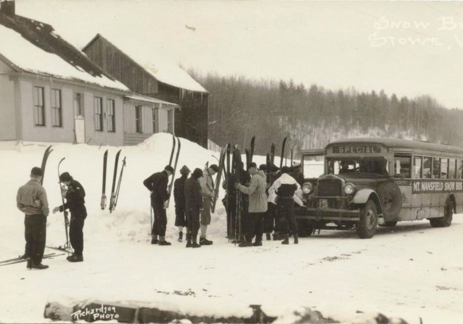 A black-and-white photo of people getting off a bus with skis.