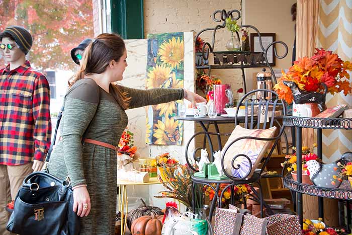 A young woman shops in a boutique stocked with gifts and unique items.