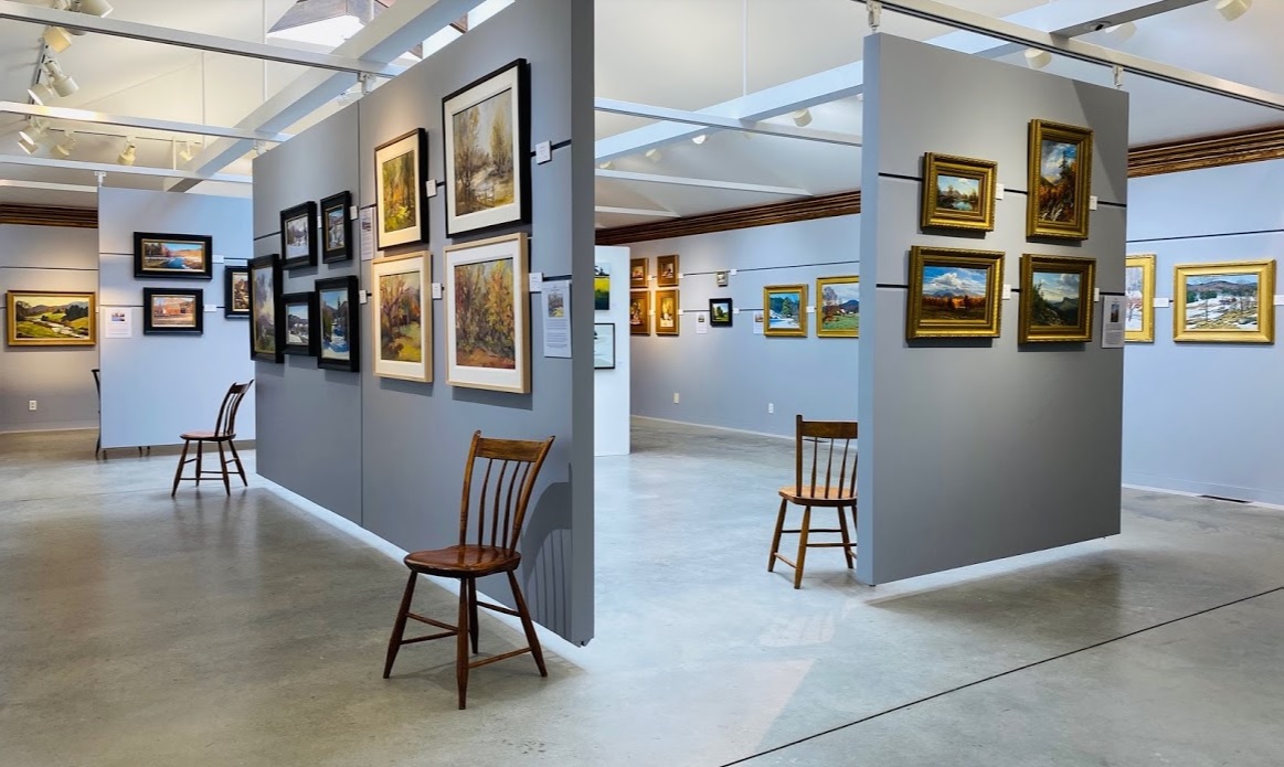 Modern lighting and art on gray panels create a gallery display.